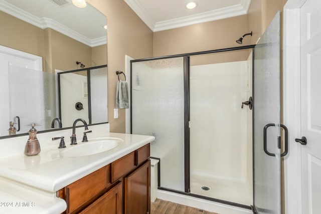 bathroom featuring hardwood / wood-style flooring, vanity, crown molding, and walk in shower