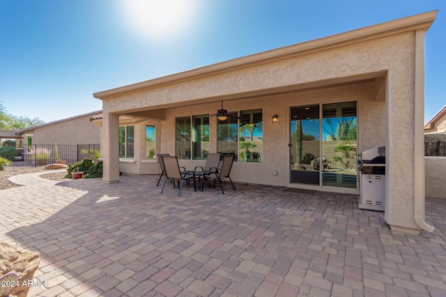 rear view of property with ceiling fan and a patio area