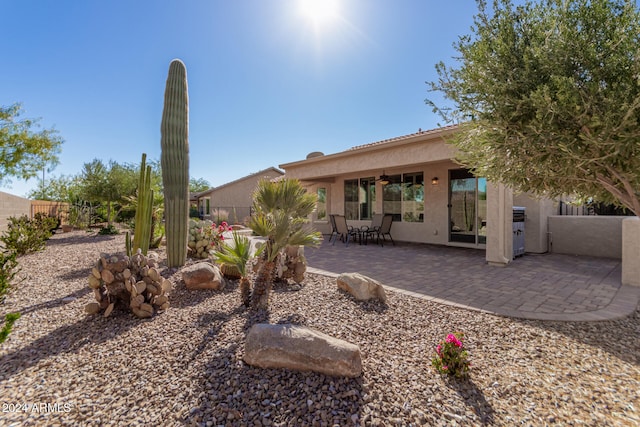 rear view of property featuring ceiling fan and a patio