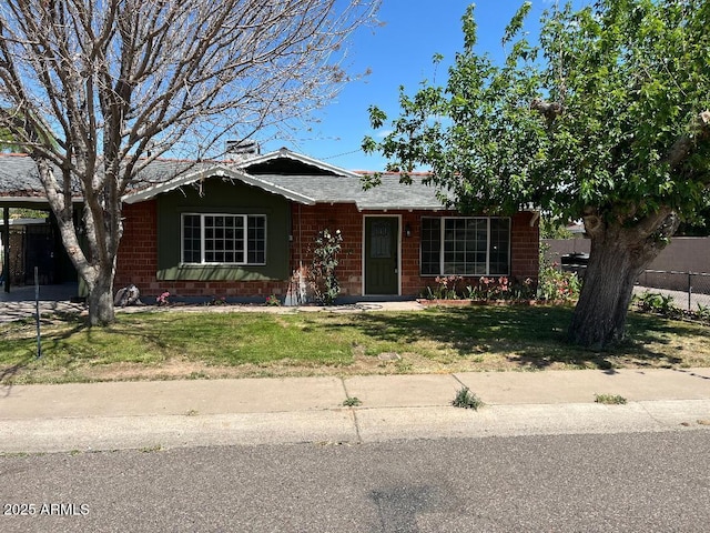 single story home with fence, brick siding, and a front lawn