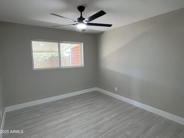 empty room with a ceiling fan, baseboards, and light wood finished floors