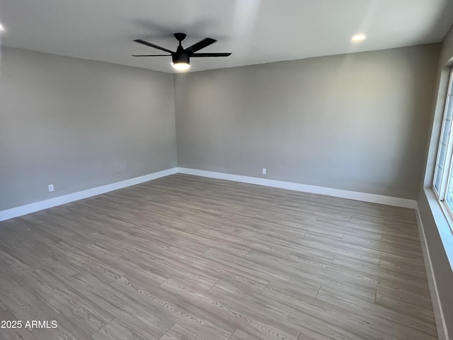 empty room featuring baseboards, ceiling fan, and wood finished floors