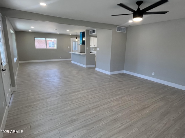 unfurnished living room featuring light wood-type flooring, a ceiling fan, visible vents, and recessed lighting