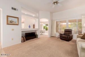 carpeted living room featuring ceiling fan