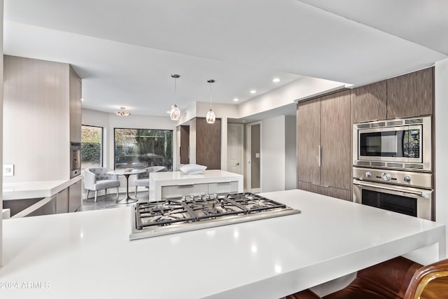 10658 E Cinnabar Ave, Scottsdale, AZ 85258 - kitchen featuring a breakfast bar, light countertops, modern cabinets, and appliances with stainless steel finishes