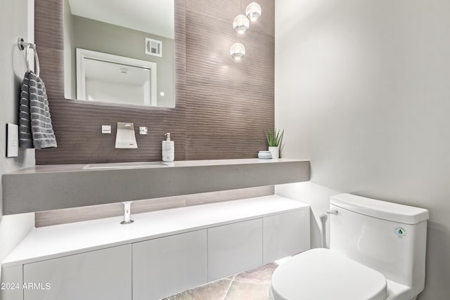 10658 E Cinnabar Ave, Scottsdale, AZ 85258 - half bathroom featuring toilet, decorative backsplash, visible vents, and a sink