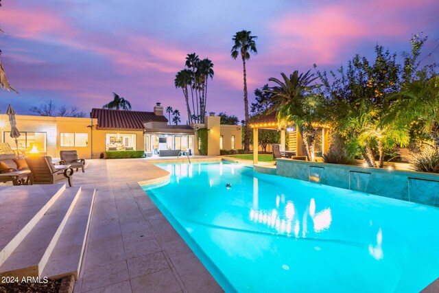 10658 E Cinnabar Ave, Scottsdale, AZ 85258 - pool at dusk featuring a patio area and an outdoor pool
