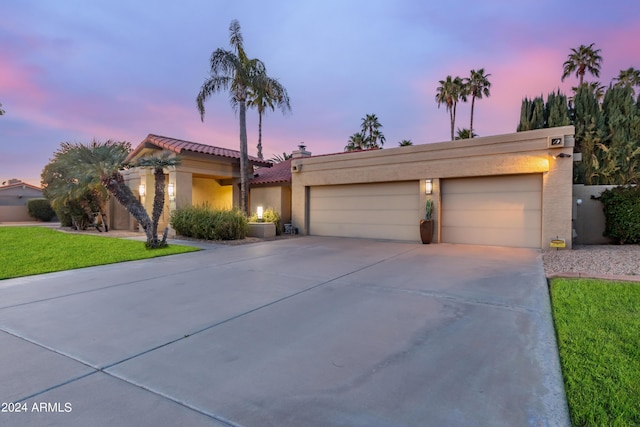 10658 E Cinnabar Ave, Scottsdale, AZ 85258 - view of front facade with driveway, a tile roof, a garage, stucco siding, and a lawn