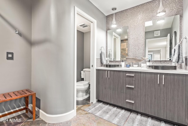 10658 E Cinnabar Ave, Scottsdale, AZ 85258 - full bathroom featuring toilet, visible vents, baseboards, tasteful backsplash, and vanity