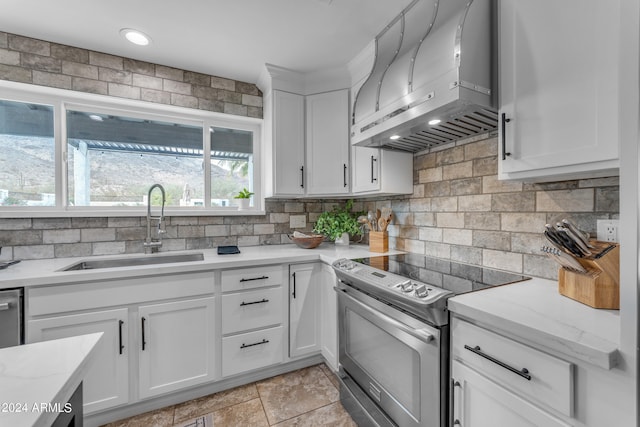 kitchen featuring white cabinets, sink, wall chimney exhaust hood, and stainless steel range with electric cooktop