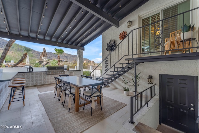 view of patio / terrace with area for grilling, a mountain view, and exterior kitchen