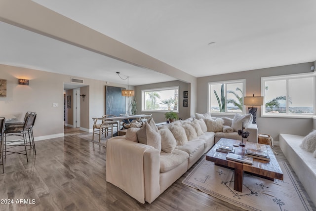 living room with hardwood / wood-style flooring and a notable chandelier