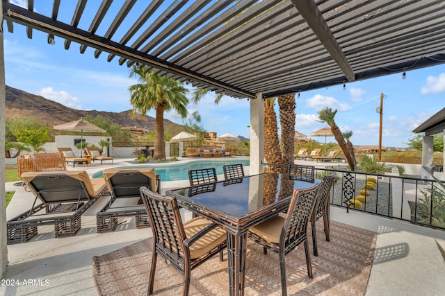 view of patio featuring a fenced in pool, a pergola, and a mountain view