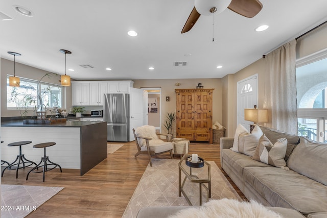 living room featuring ceiling fan and light hardwood / wood-style floors