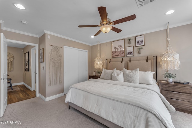 bedroom featuring ceiling fan, carpet, a closet, and crown molding