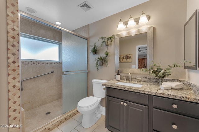 bathroom with a shower with shower door, toilet, vanity, and tile patterned flooring