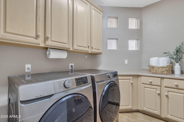 washroom featuring cabinets, light wood-type flooring, and independent washer and dryer