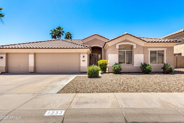 1333 W Deer Creek Rd, Phoenix, AZ 85045 - mediterranean / spanish home featuring a tiled roof, a garage, stucco siding, and driveway