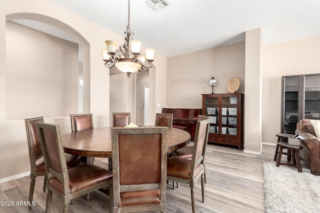 1333 W Deer Creek Rd, Phoenix, AZ 85045 - dining area with arched walkways, a chandelier, baseboards, light wood-type flooring, and visible vents