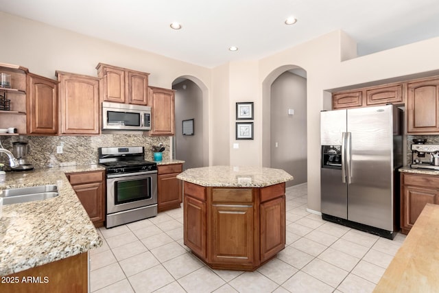 1333 W Deer Creek Rd, Phoenix, AZ 85045 - kitchen with open shelves, arched walkways, a sink, appliances with stainless steel finishes, and backsplash