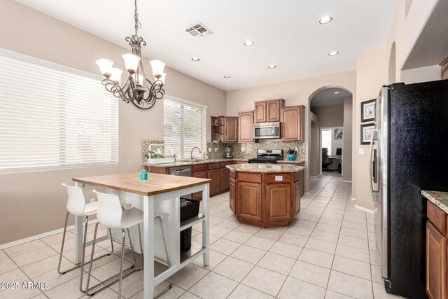 1333 W Deer Creek Rd, Phoenix, AZ 85045 - kitchen with open shelves, a sink, stainless steel appliances, a kitchen island, and visible vents