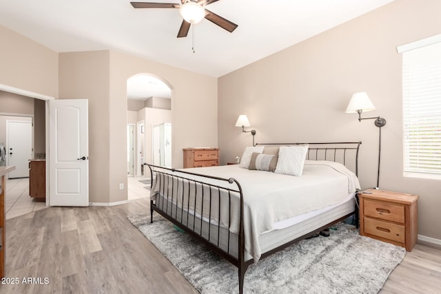 1333 W Deer Creek Rd, Phoenix, AZ 85045 - bedroom with a ceiling fan, light wood-style floors, baseboards, ensuite bathroom, and arched walkways