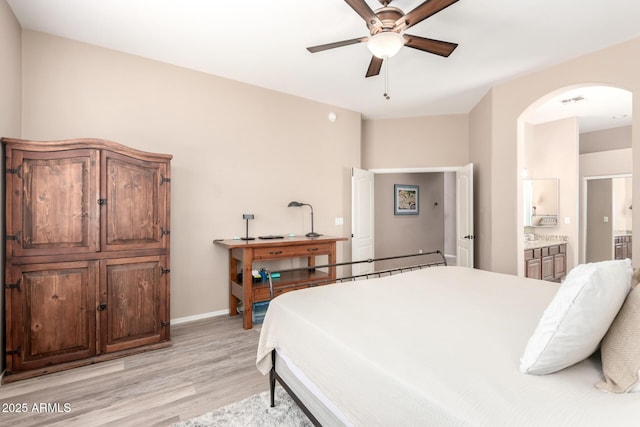 1333 W Deer Creek Rd, Phoenix, AZ 85045 - bedroom featuring ensuite bathroom, baseboards, ceiling fan, arched walkways, and light wood-style flooring