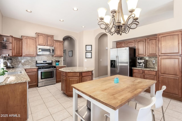 1333 W Deer Creek Rd, Phoenix, AZ 85045 - kitchen with arched walkways, a center island, open shelves, a sink, and stainless steel appliances