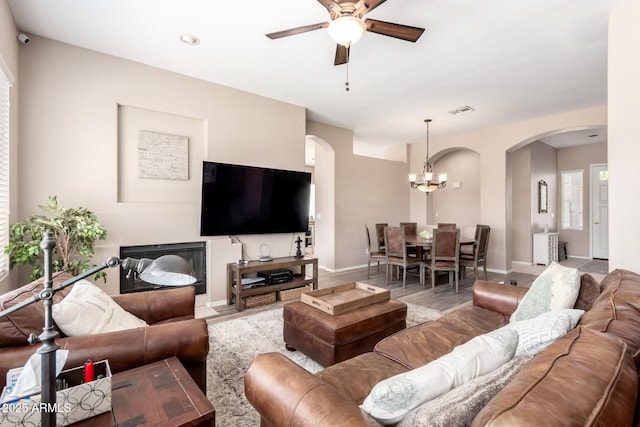 1333 W Deer Creek Rd, Phoenix, AZ 85045 - living area featuring arched walkways, ceiling fan with notable chandelier, baseboards, wood finished floors, and visible vents