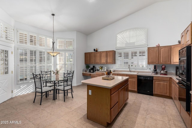 kitchen featuring a center island, light countertops, hanging light fixtures, a sink, and black appliances