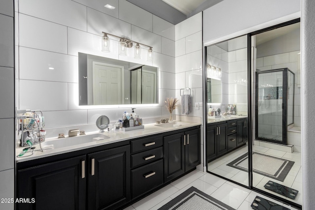 full bath featuring a stall shower, a sink, tile walls, and double vanity