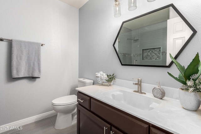 full bathroom featuring a stall shower, vanity, and toilet