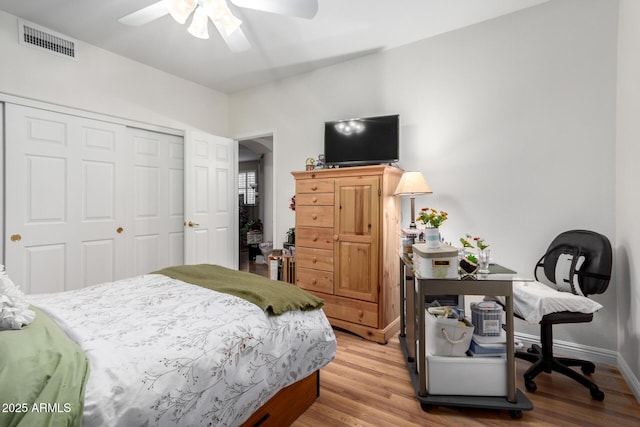 bedroom featuring baseboards, visible vents, ceiling fan, wood finished floors, and a closet