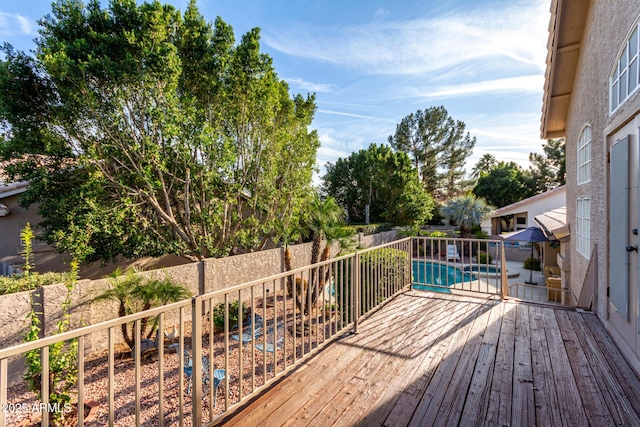 wooden deck featuring a fenced backyard and a fenced in pool