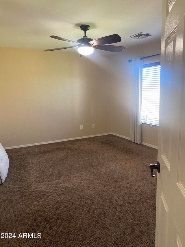 carpeted spare room with ceiling fan