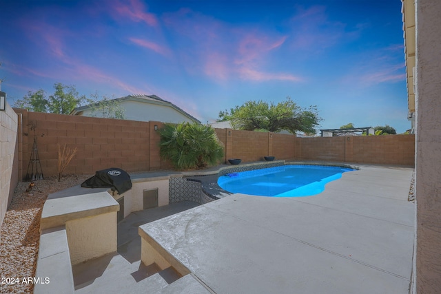 pool at dusk with a patio area