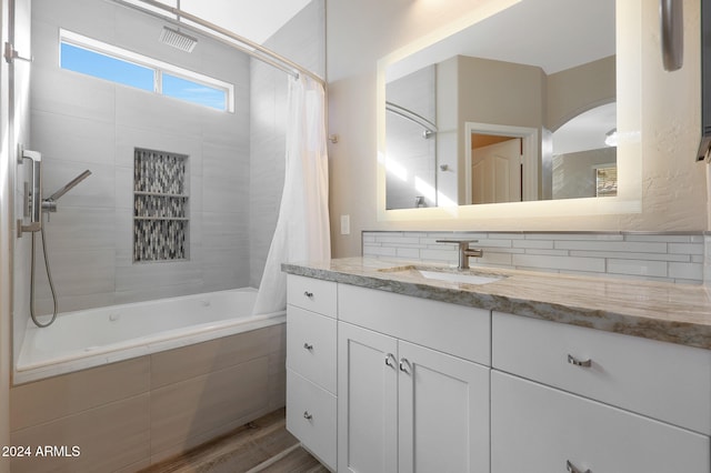 bathroom featuring tasteful backsplash, hardwood / wood-style floors, vanity, and shower / tub combo