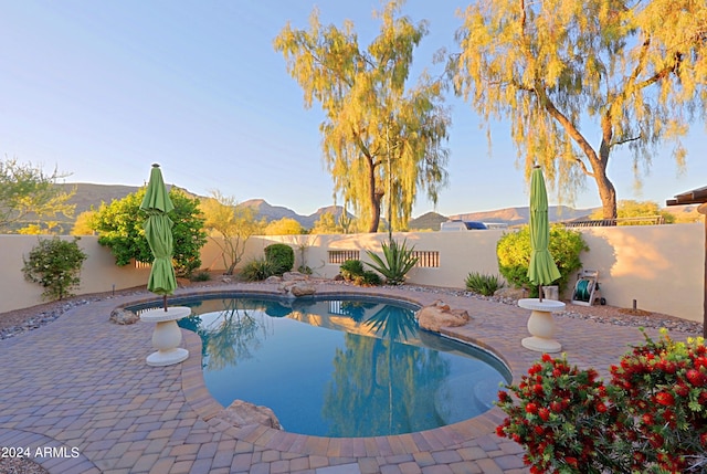 view of swimming pool with a patio area and a mountain view