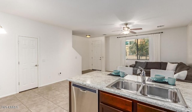 kitchen with open floor plan, light countertops, stainless steel dishwasher, and a sink