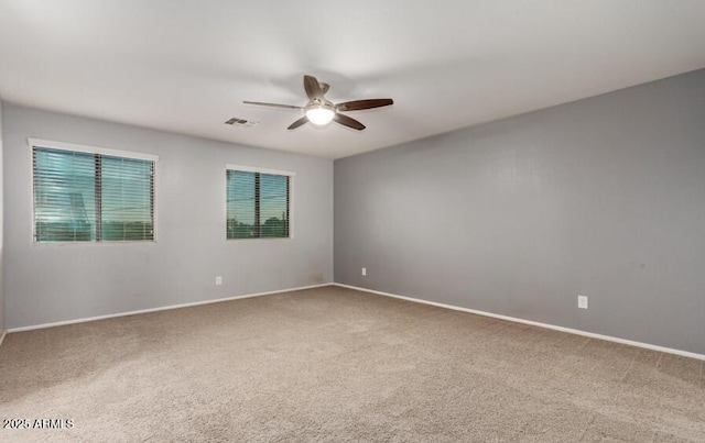 unfurnished room with a ceiling fan, carpet, visible vents, and baseboards