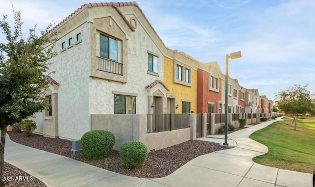 view of building exterior with a fenced front yard and a residential view