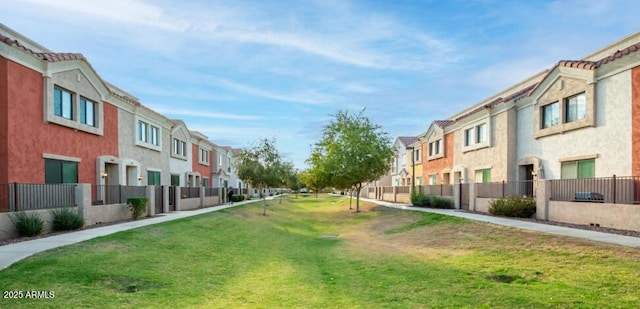 view of community with a yard, a residential view, and fence