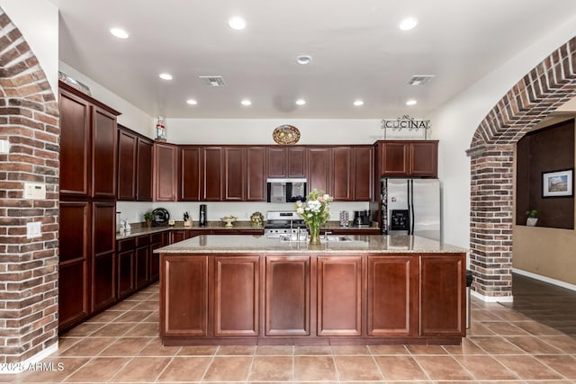 3441 S Halsted Pl, Chandler, AZ 85286 - kitchen featuring appliances with stainless steel finishes, recessed lighting, a center island with sink, light stone counters, and a sink