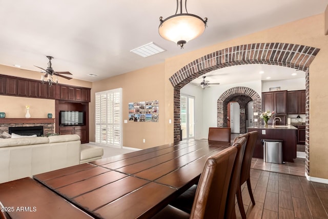 3441 S Halsted Pl, Chandler, AZ 85286 - dining area featuring a ceiling fan, arched walkways, a stone fireplace, baseboards, and recessed lighting