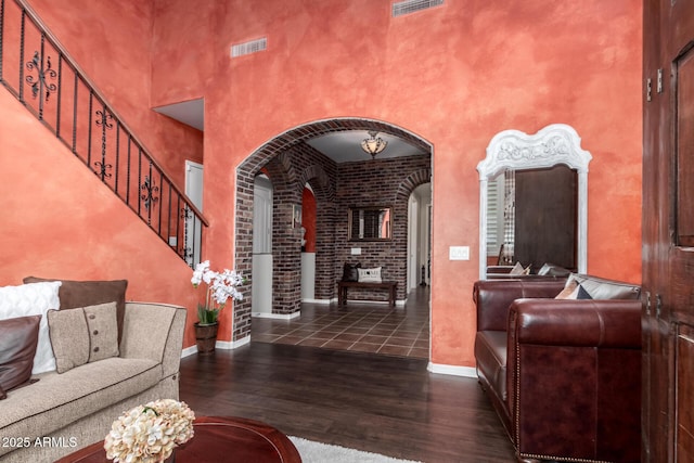 3441 S Halsted Pl, Chandler, AZ 85286 - living room with arched walkways, a towering ceiling, wood finished floors, stairs, and baseboards