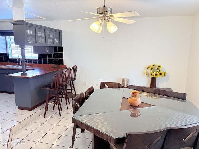 dining space featuring light tile patterned flooring and a ceiling fan