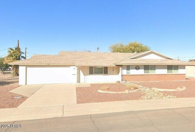 ranch-style house featuring concrete driveway and an attached garage