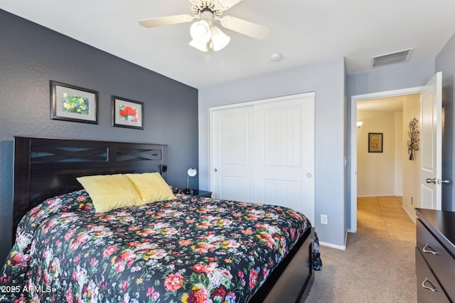 carpeted bedroom with baseboards, a closet, visible vents, and a ceiling fan