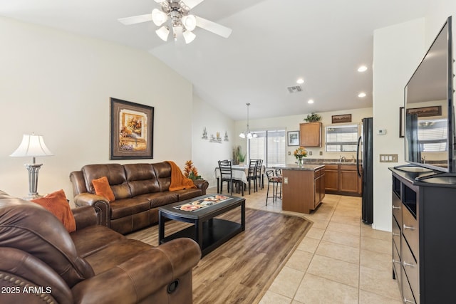 living room featuring light tile patterned floors, recessed lighting, visible vents, a ceiling fan, and vaulted ceiling