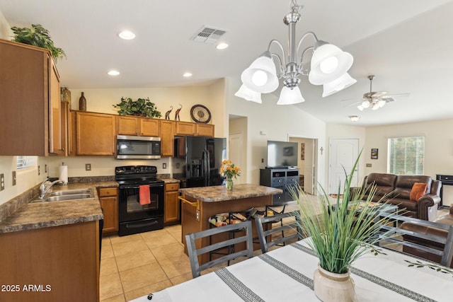 kitchen with a sink, visible vents, brown cabinets, black appliances, and dark countertops